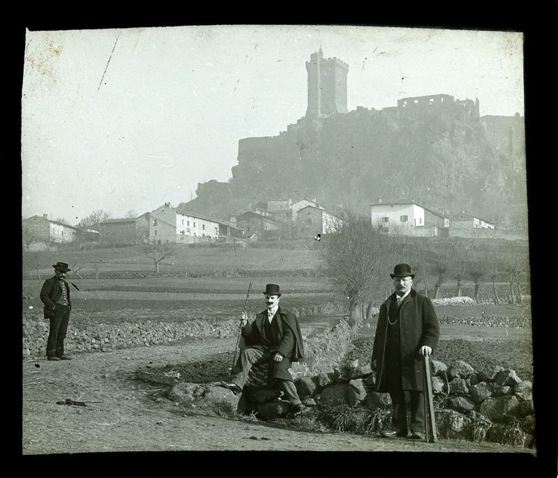 Archives départementales de la Haute-Loire. Collection de plaques de verre photographiques (hommes en chapeaux devant la forteresse de Polignac, 29 FI 36). 