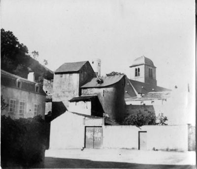 Archives départementales de la Haute-Loire. Lieu non identifié. Maison-forte avec une église en arrière-plan (47 Fi 24).